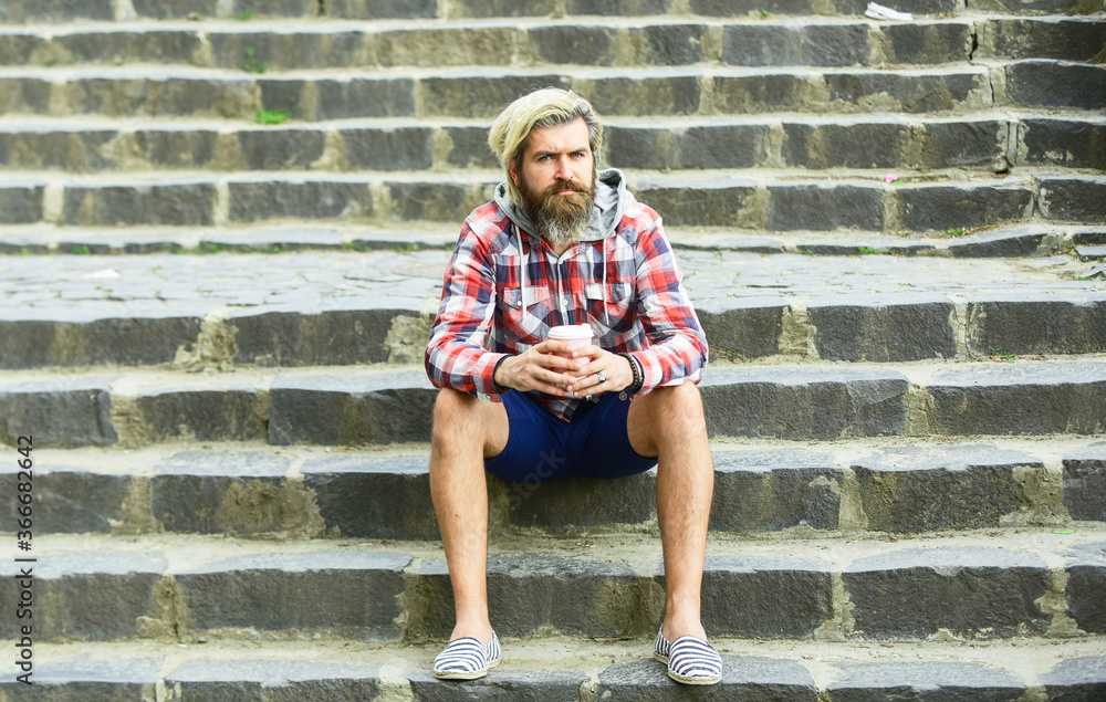 Batch brew is pour over coffee. Man with beard drinking coffee. Bearded man drink beverage urban background. Hipster relax on stairs. Having rest. Take away coffee. Caffeine dose. Filter coffee Batch brew is pour over coffee. Man with beard drinking coffee. Bearded man drink beverage urban background. Hipster relax on stairs. Having rest. Take away coffee. Caffeine dose. Filter coffee
