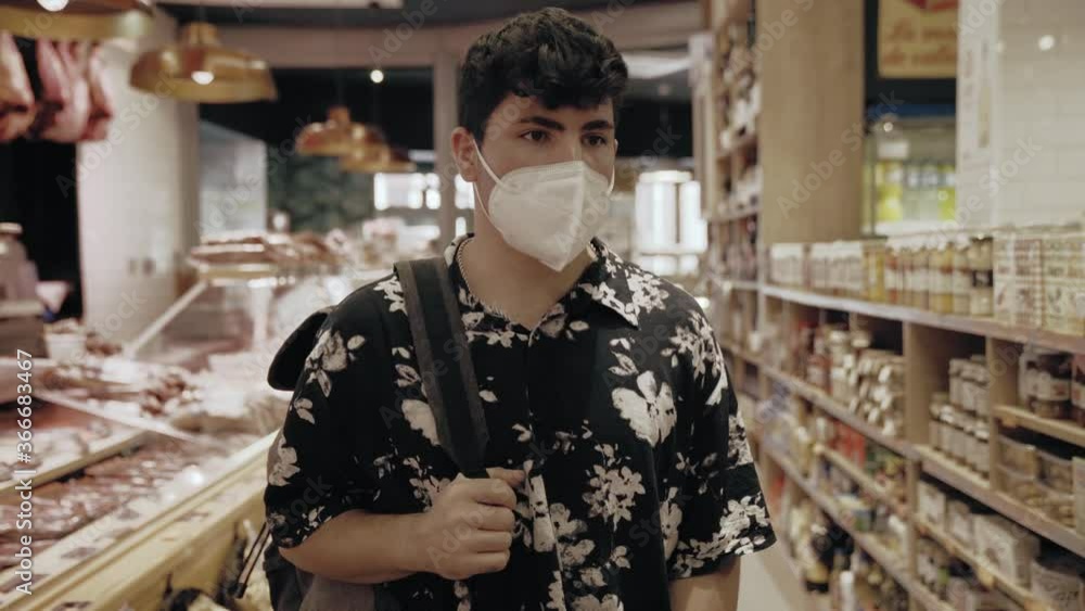 Hombre caucásico con camisa vintage comprando ropa en una tienda de ropa vintage con mascarilla covid coronavirus