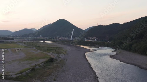 Slow aerial push upriver along Gifu Nagaragawa at sunrise photo