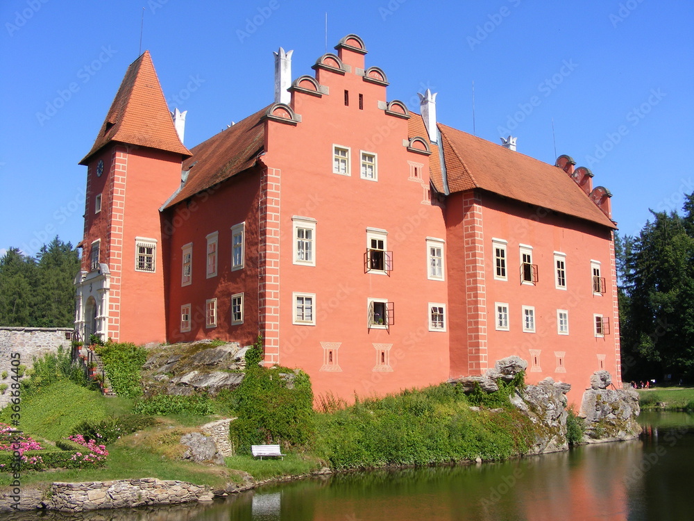 view of a water castle surrounded by a lake with distinctive red plaster, Southern Bohemia, Czech Republic view of a water castle surrounded by a lake with distinctive red plaster, Southern Bohemia, Czech Republic