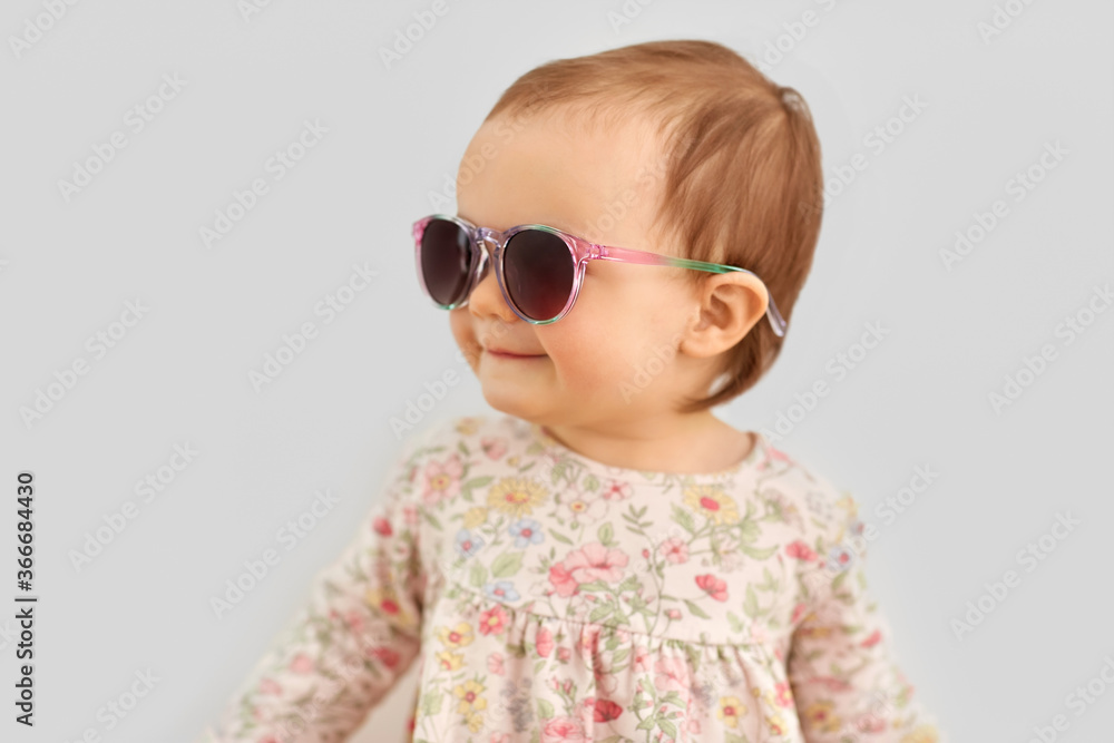 childhood, summer and people concept - happy little baby girl in sunglasses over grey background childhood, summer and people concept - happy little baby girl in sunglasses over grey background