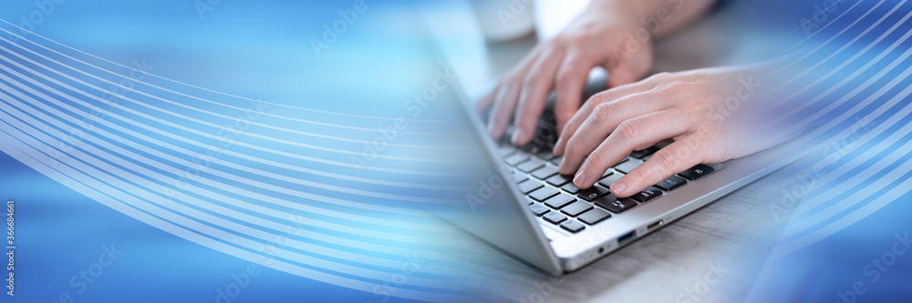 Female hands using laptop; panoramic banner Female hands using laptop; panoramic banner