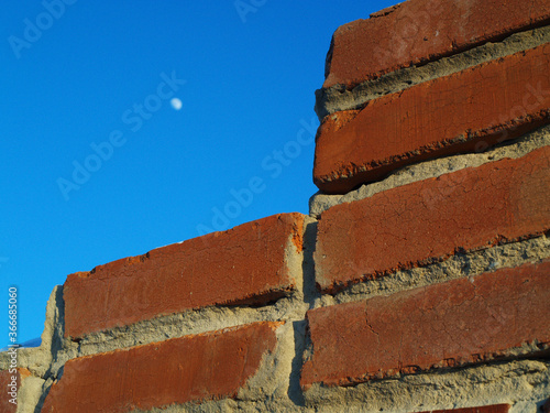 Old brick wall with blue sky Brick wall against the sky with the moon