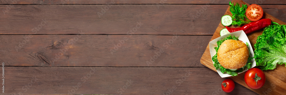 Ingredients for making a burger. Burger on a dark wooden background. Top view, flat lay. Banner Ingredients for making a burger. Burger on a dark wooden background. Top view, flat lay. Banner