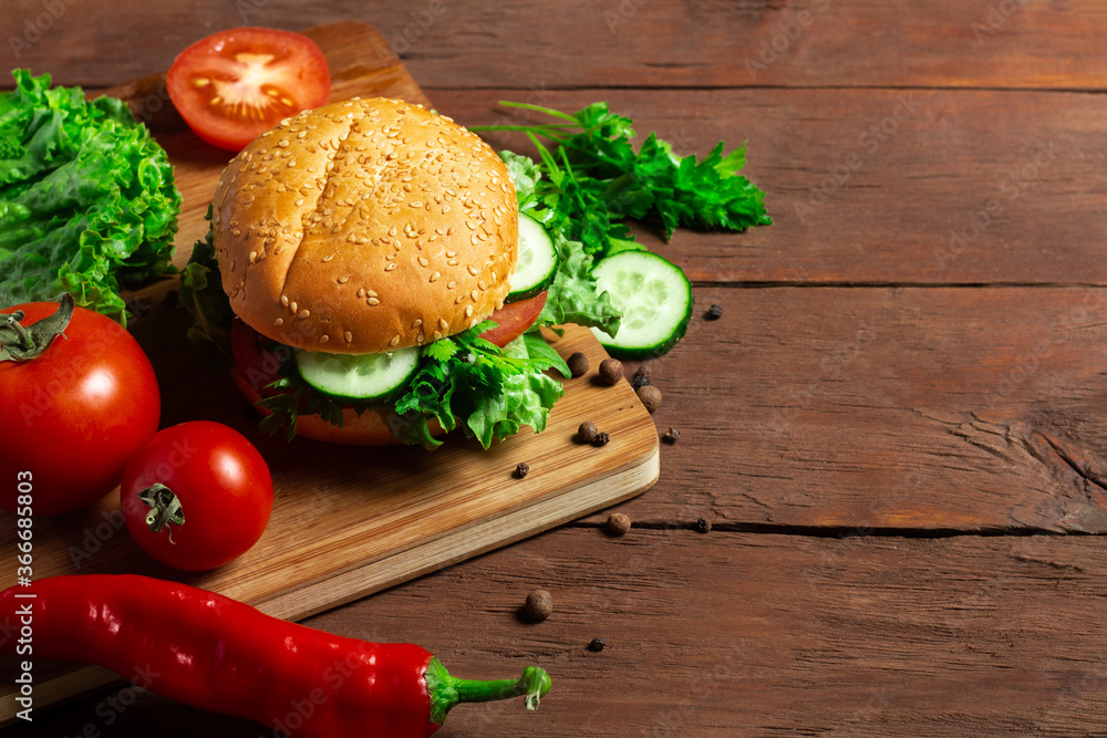 Fresh vegetarian burger on a dark wooden background. Salad, vegetables Fresh vegetarian burger on a dark wooden background. Salad, vegetables