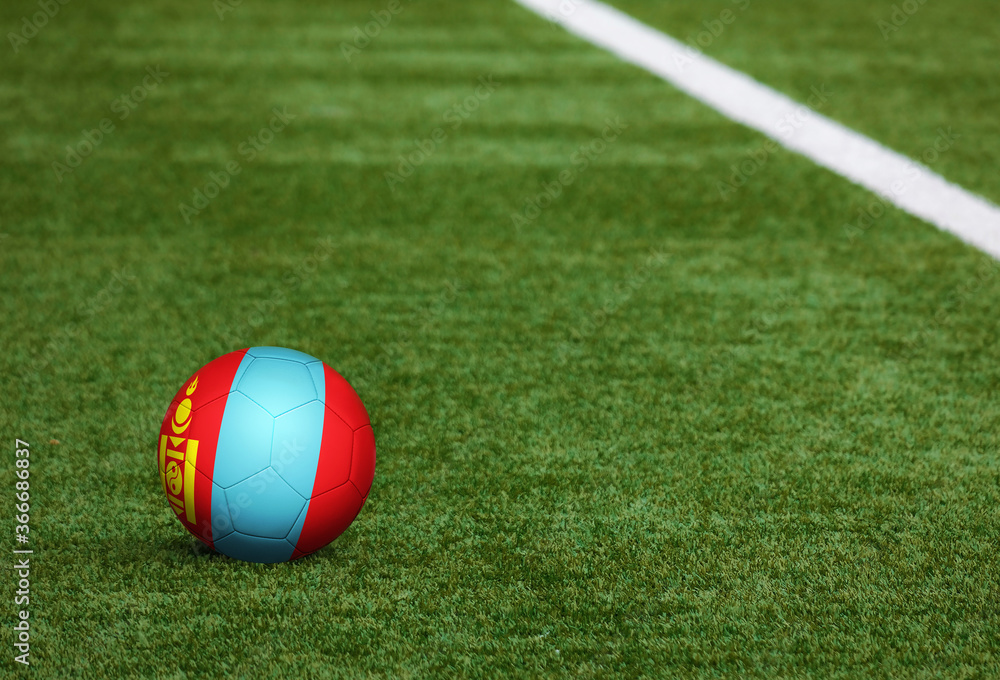 Mongolia flag on ball at soccer field background. National football theme on green grass. Sports competition concept. Mongolia flag on ball at soccer field background. National football theme on green grass. Sports competition concept.