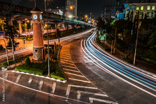Wallpaper Mural Car lights at night on the road going to the city with clock tower time. Aerial view of the speed traffic trails on motorway highway in Yannawa, Rama 3, Bangkok, Thailand. Long exposure abstract Torontodigital.ca