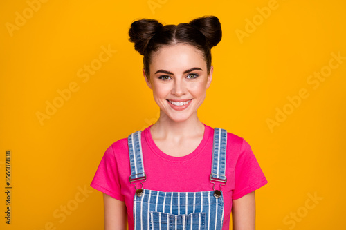 Photo of pretty brunette lady teenager two cute buns good mood beaming smile wear casual striped denim overall magenta t-shirt isolated bright yellow color background
