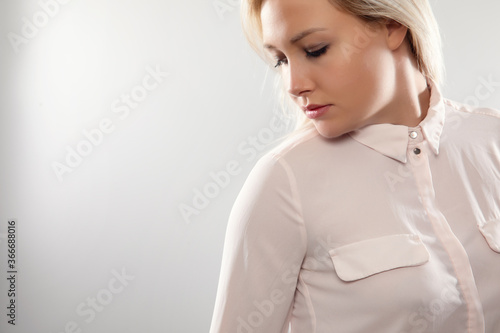 Billede på lærred Pensive beautiful female blonde model in shirt looking away from camera