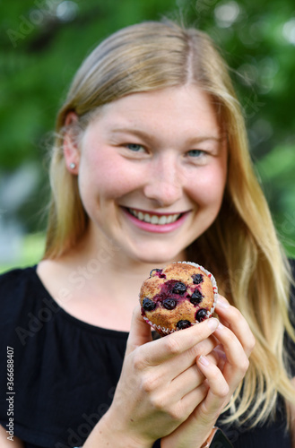 Young beautiful woman eating unhealthy food snack in lunch break, smiling happy. Focus on a meal. Czech Republic, Europe.