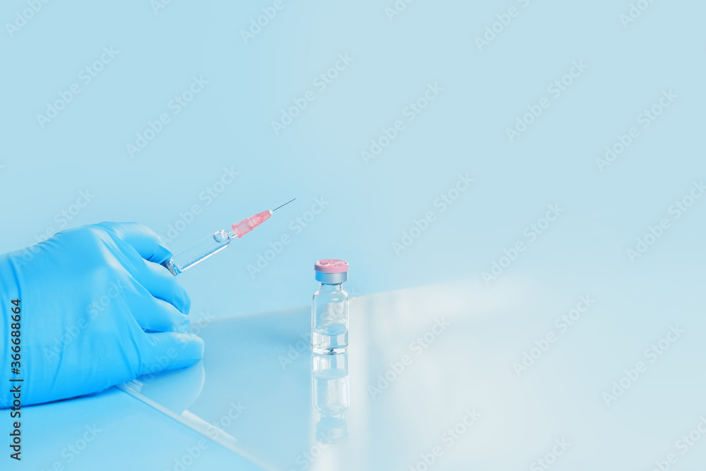 Syringe in a hand of a doctor or nurse and medicine or vaccine vial. Vaccination and immunization concept. Medicine and health care. Vaccine trials and research. Pharmacy. Copy space Syringe in a hand of a doctor or nurse and medicine or vaccine vial. Vaccination and immunization concept. Medicine and health care. Vaccine trials and research. Pharmacy. Copy space