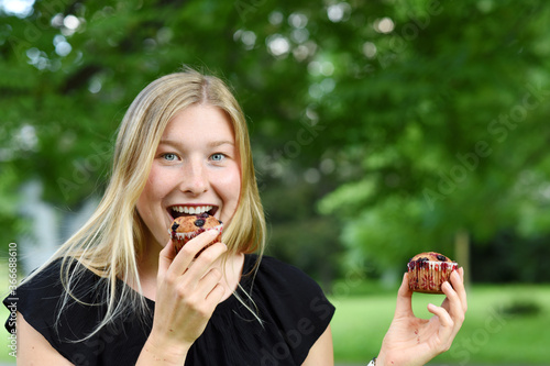 Young beautiful woman eating unhealthy food snack in lunch break  smiling happy. Focus on a meal. Czech Republic  Europe.