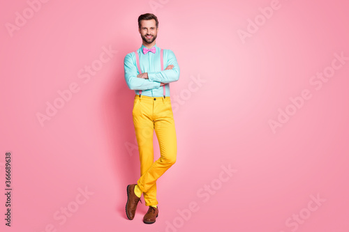 Full length photo of handsome guy trend clothes red carpet celebrity arms crossed photographing posing wear shirt suspenders bow tie yellow pants shoes isolated pastel pink color background