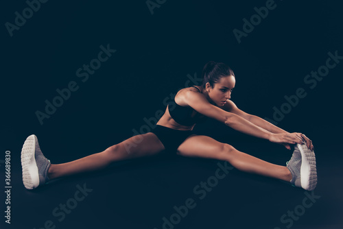 Portrait of her she nice-looking attractive sportive confident flexible strong muscular lady working out perfection form correction sculpt isolated over black background © deagreez