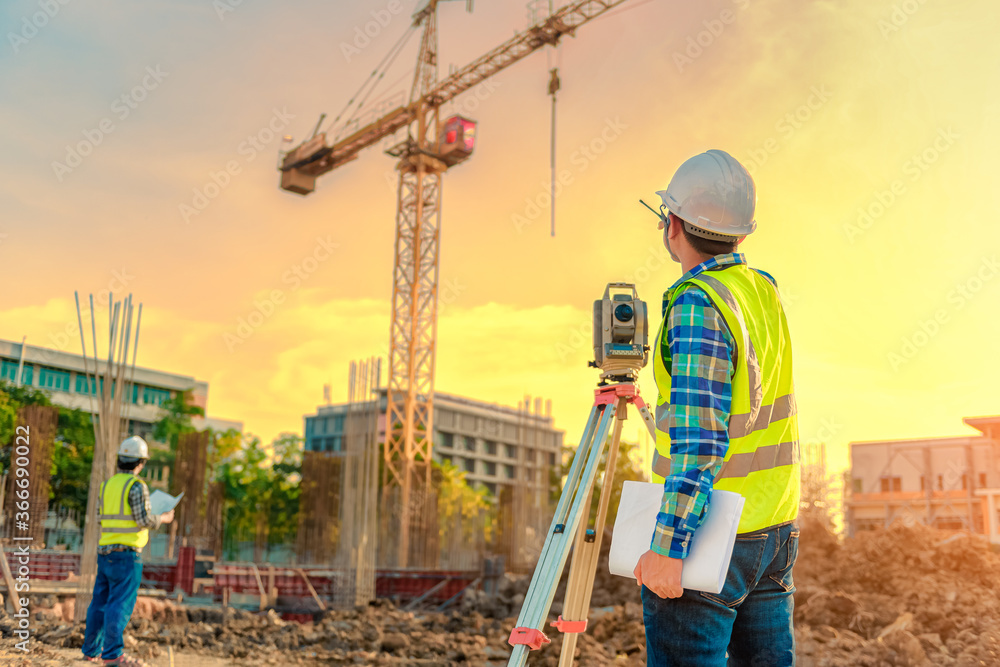 Fototapeta premium Surveying engineers are working together using theodolite on the construction site.
