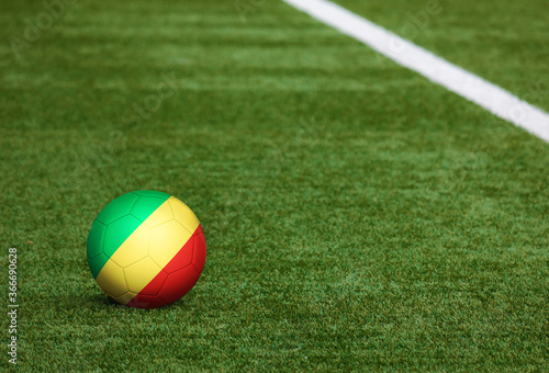 Republic Of The Congo flag on ball at soccer field background. National football theme on green grass. Sports competition concept.