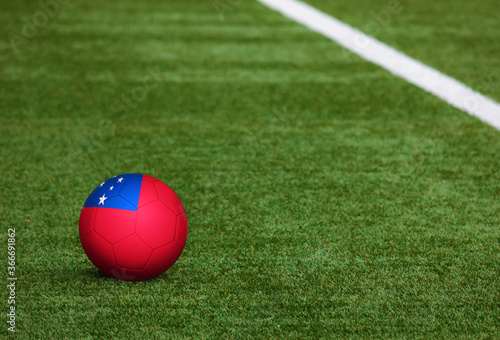 Samoa flag on ball at soccer field background. National football theme on green grass. Sports competition concept.