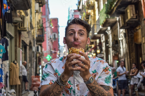Young man eating street food in Italy during the holidays