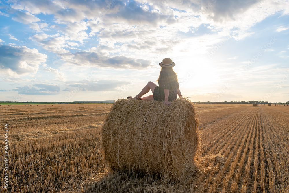 Girl at sunset in a field with hay. Girl at sunset in a field with hay.
