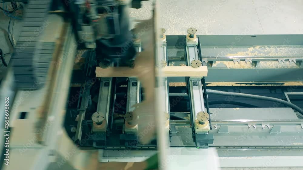Factory machine is processing a wooden bar Factory machine is processing a wooden bar
