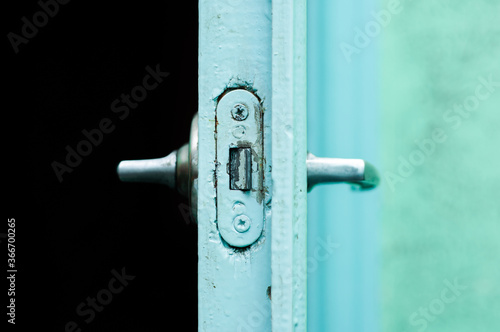 Door lock tongue of an old blue painted wooden door