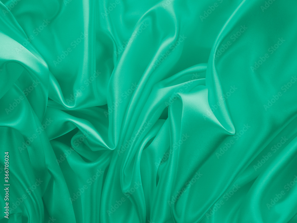 Obraz premium Beautiful elegant wavy light green satin silk luxury cloth fabric texture, abstract background design. Card or banner.