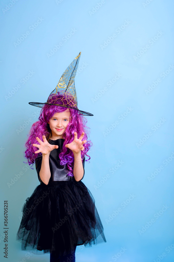 Happy Halloween. Blonde  girl kid in a witch costume on a blue background. Place for text, place for copying. 
