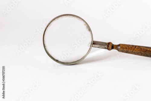 Old magnifying glass on a light background.