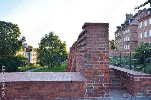 The historic defense walls of the Barbican in Warsaw's Old Town during sunrise.