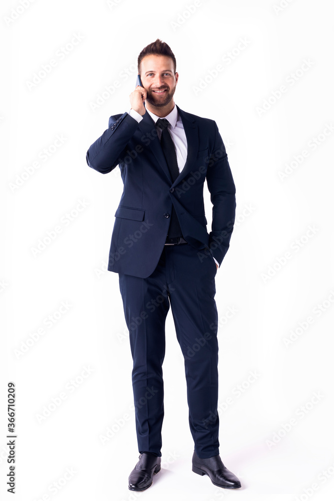 Studio shot of handsome businessman wearing suit and using phone while standing at isolated white background Studio shot of handsome businessman wearing suit and using phone while standing at isolated white background