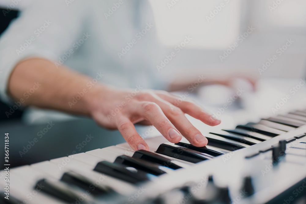 Obraz premium young man's hands playing keyboard piano, composing music , music record concep, art, song composition, melody