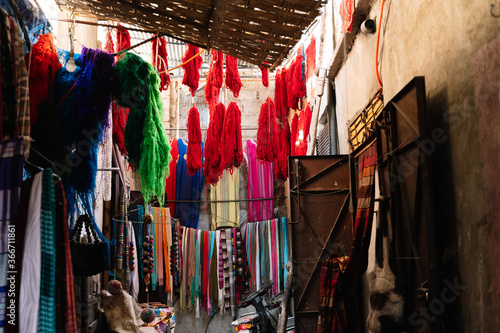 Market stand with colored silk threads and scarfs on the street in Morocco
