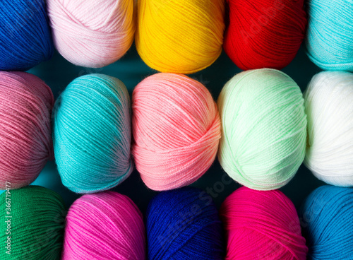Colorful multicolored background from skeins of acrylic yarn. Textile industry.