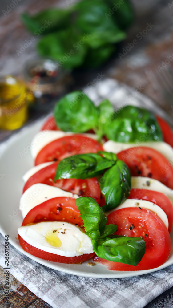 Selective focus. Appetizing Caprese salad on a plate. Traditional Italian appetizer.