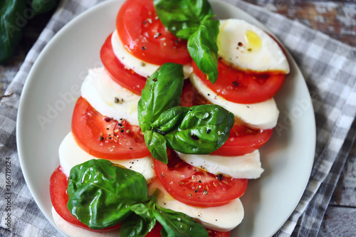 Selective focus. Appetizing Caprese salad on a plate. Traditional Italian appetizer.