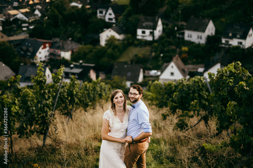 Smiling couple stand among vineyard in embrance Smiling couple stand among vineyard in embrance