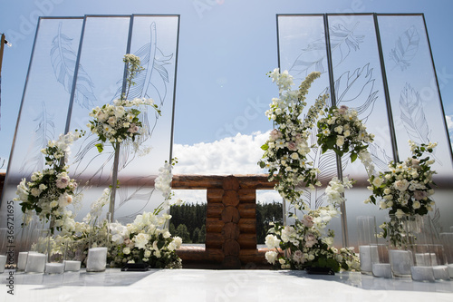 Wedding ceremony with white transparent screens and fresh white flowers and candles