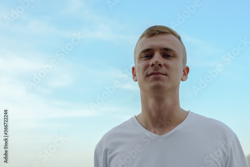 Portrait of young blond man against view of the clear sky