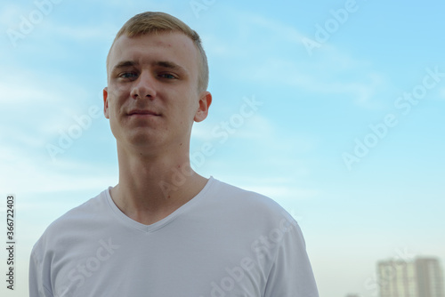 Portrait of young blond man against view of the clear sky