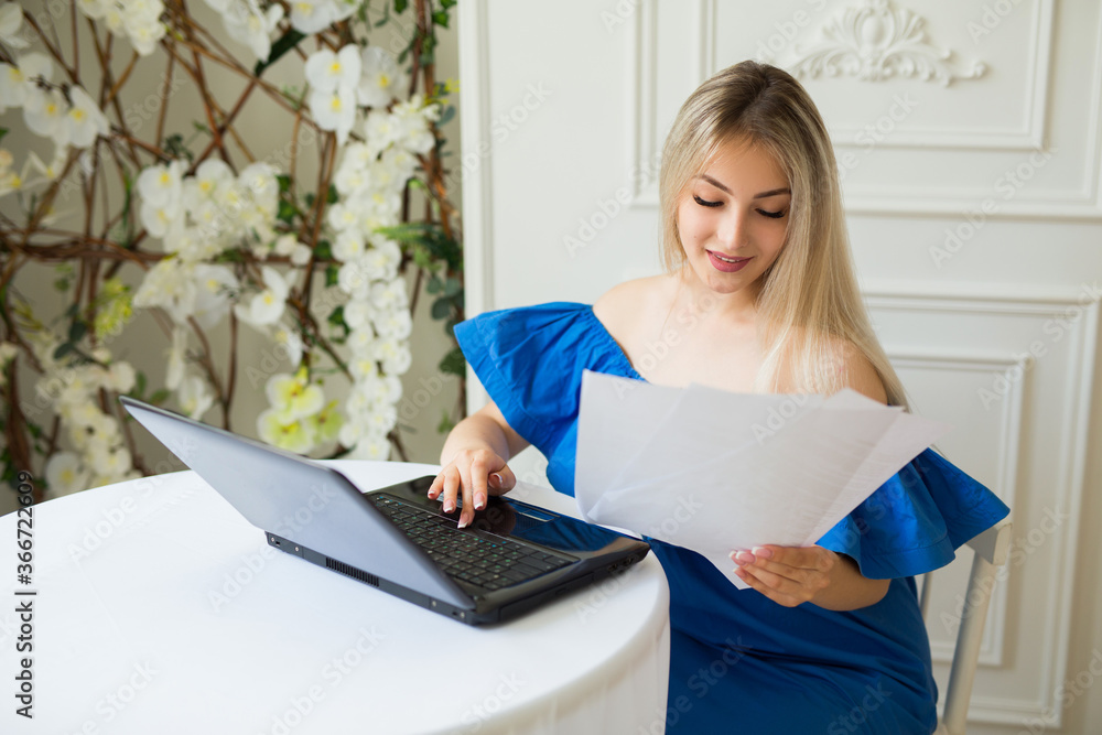 beautiful young female with loose hair sits at a table with a laptop beautiful young female with loose hair sits at a table with a laptop