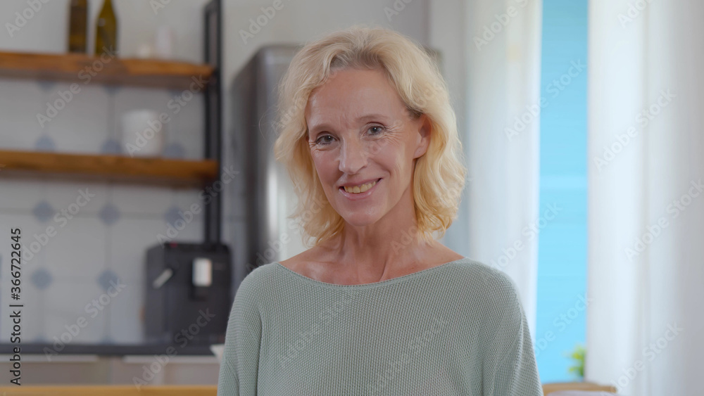 Successful mature woman at home smiling looking at camera. Successful mature woman at home smiling looking at camera.