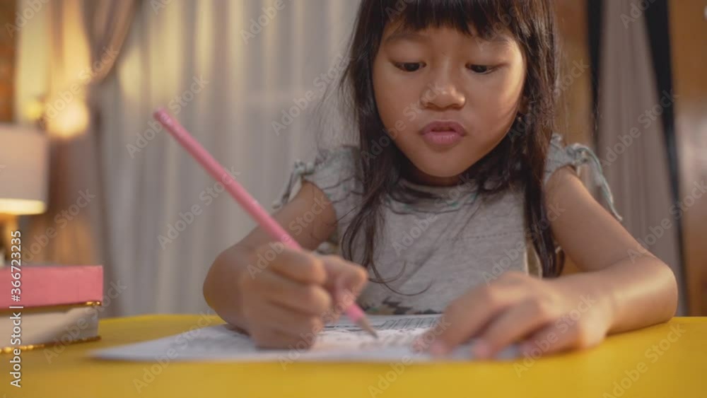 little elementary school student asian kid studying by herself in the evening little elementary school student asian kid studying by herself in the evening