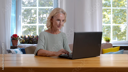 Senior woman with laptop working at home office