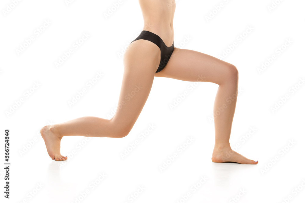 Beautiful female legs, buttlocks during sport isolated on white background. Beauty, cosmetics, spa, depilation, treatment and fitness concept. Sportive, sensual body with well-kept skin in underwear.