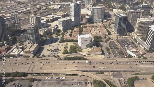 Aerial Busy Traffic on Highway in Downtown Dallas showing Skyscrapers and large Buildings in background - Sunny Weather and Clear sky