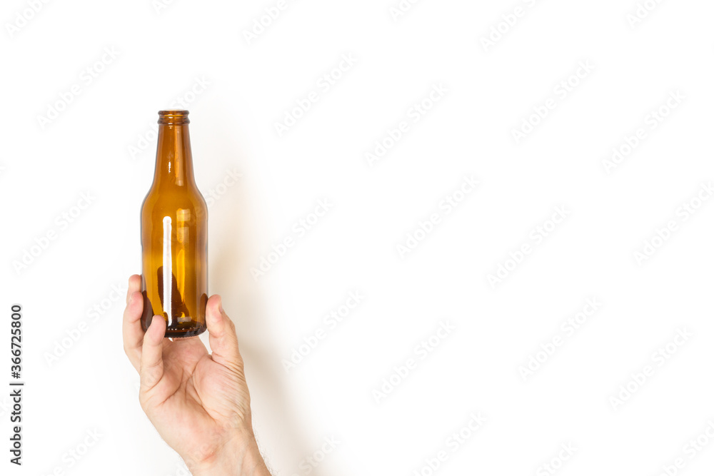 Mano de un hombre sosteniendo una botella de cerveza sobre un fondo liso y aislado blanco. Vista de frente. Copy space Mano de un hombre sosteniendo una botella de cerveza sobre un fondo liso y aislado blanco. Vista de frente. Copy space