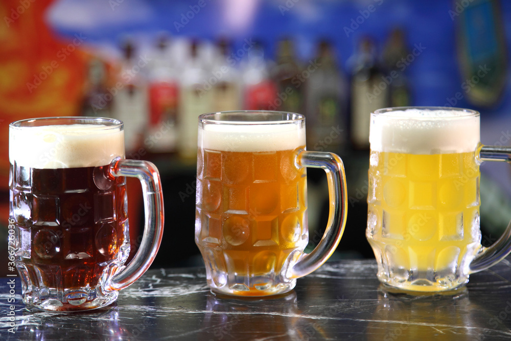 Glasses with different sorts of craft beer. Red, bronze and white beer in beer glasses on the bar. Glasses of light and dark beer on a pub background. Glasses with different sorts of craft beer. Red, bronze and white beer in beer glasses on the bar. Glasses of light and dark beer on a pub background.