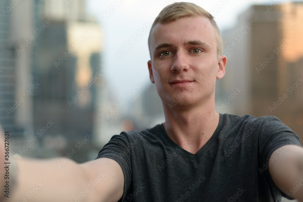 Portrait of young man with blond hair against view of the city Portrait of young man with blond hair against view of the city