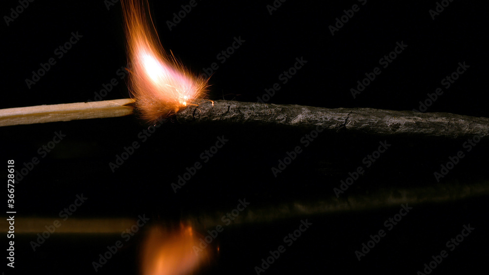 Igniting an explosive fuse from a burning match in the dark. Igniting an explosive fuse from a burning match in the dark.