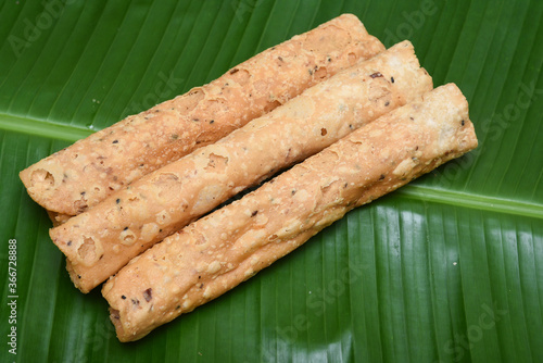 Indian fried snack Kuzhalappam Kerala fried snacks food on banana leaf background. Kerala tea time food fried in coconut oil. Top view of South Indian snacks. photo